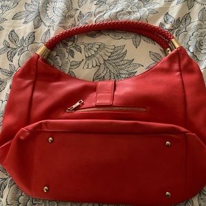 Red faux leather purse with braided handle and gold decorations